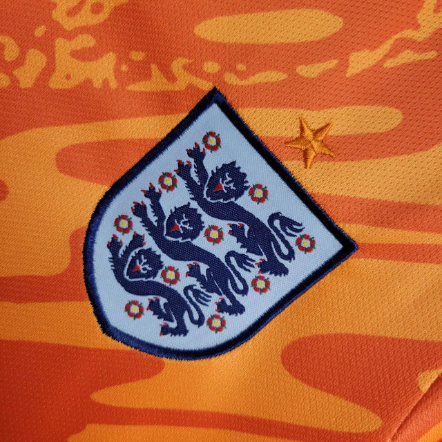 Kit Infantil Inglaterra Goleiro 2024/25 Nike na cor laranja vibrante, com camisa e shorts oficiais, escudo bordado da seleção inglesa e tecnologia Dri-FIT para máximo conforto."
